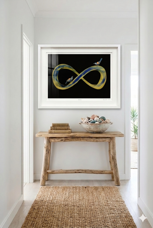 Gold and dark blue infinity symbol with two tieke birds perched on it. Black background with white frame situated in a modern home.