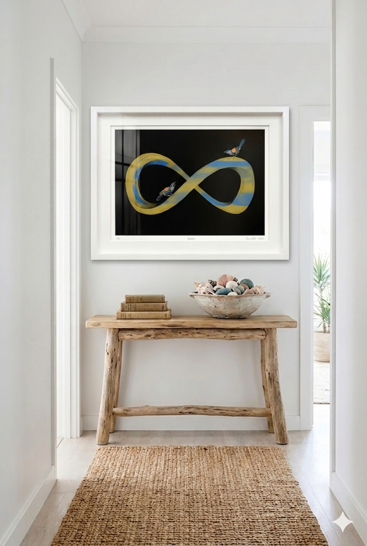 Golden infinity symbol with light mauve colour and two tieke birds perched on it. White frame and in a modern home setting