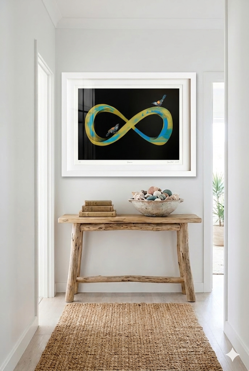 Gold and blue infinity symbol with two tieke birds perched on it in a white frame. Situated in a modern home setting