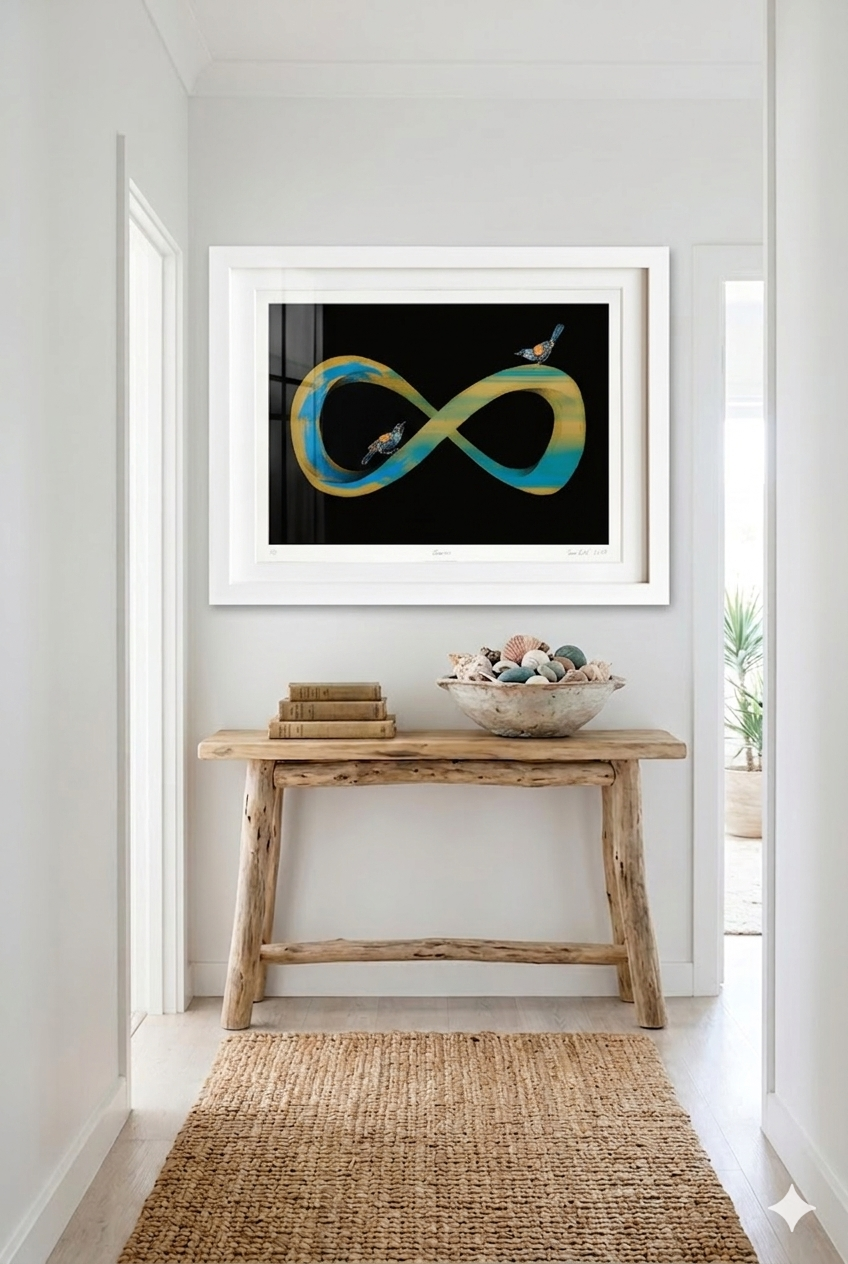 Framed artwork of an infinity symbol with birds on a black background and in a white frame. Situated in a modern home setting.