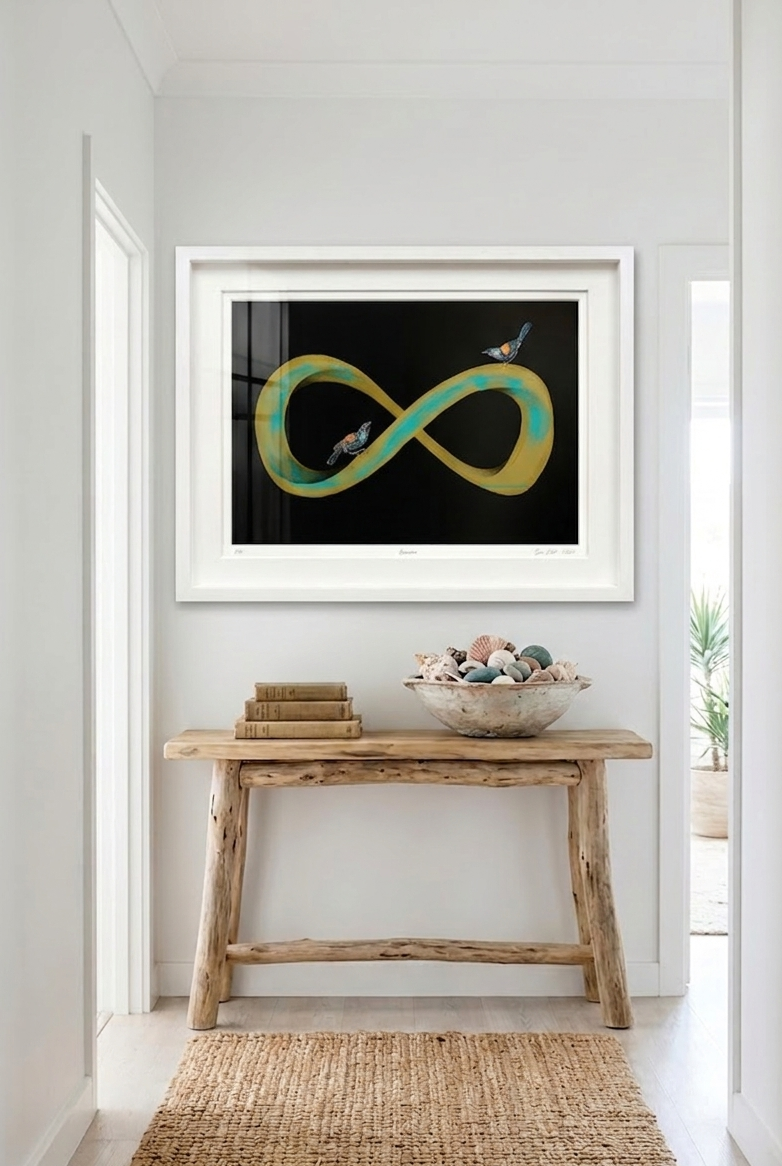 Gold and green infinity symbol artwork in a a white frame. Situated in a home setting above a table